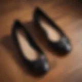 Elegant all black Tory Burch flats showcased on a wooden surface