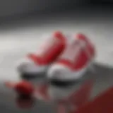 Stylish red and white gym shoes on a reflective surface