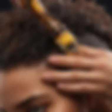 The Application of African Oils in Hair Care Close-up of a hand applying African oil to hair, illustrating its use in personal care