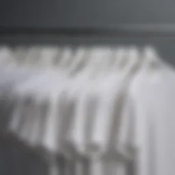 A variety of plain white t-shirts displayed on hangers
